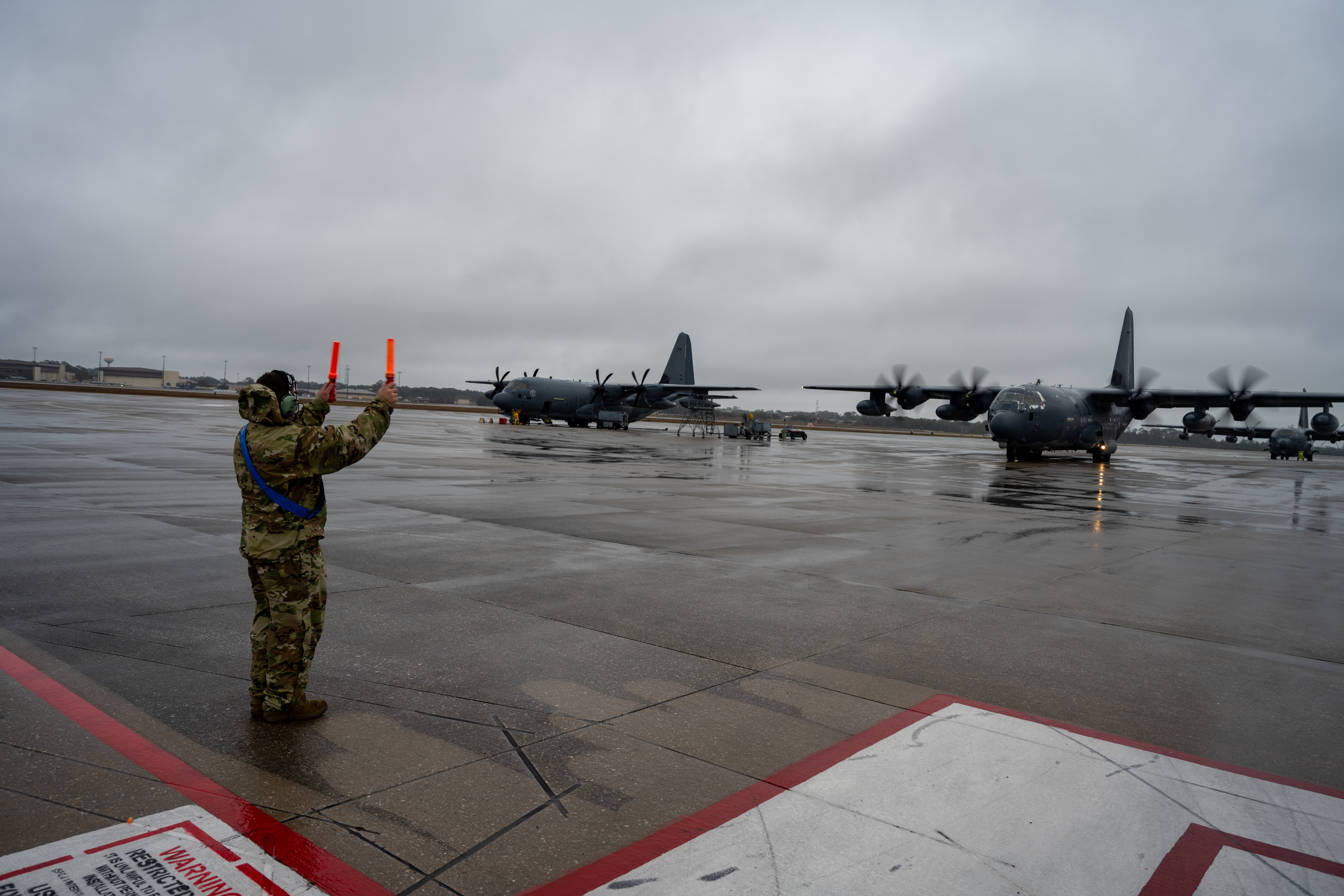 A U.S. Air Force crew chief assigned to the 1st Special Operations Wing marshals a crew aboard an MC-130J Commando II to the runway at Hurlburt Field, Florida, Feb. 19, 2025.