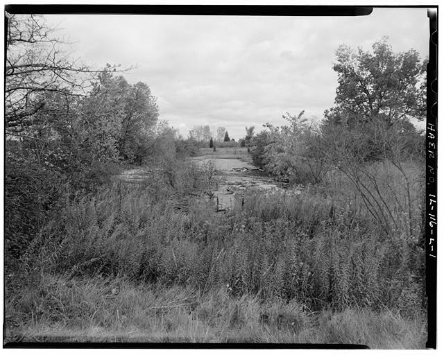 CONCRETE PAD, NORTH END OF OFFICERS QUARTERS, LOOKING EAST